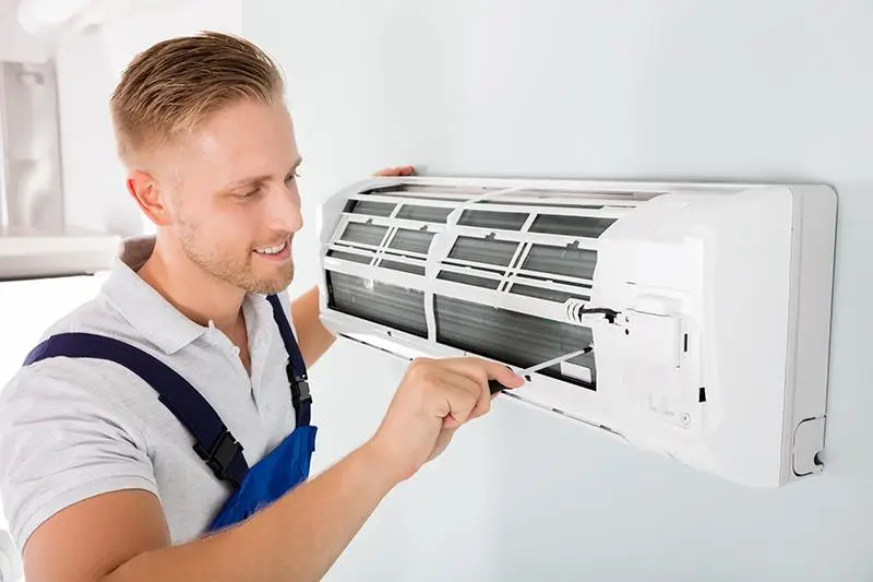 Técnico reparando un sistema de aire acondicionado