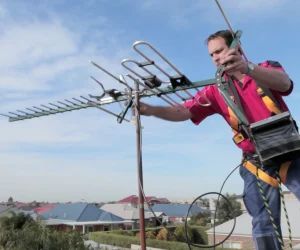 Imagen de un técnico instalando una antena de señal de TV